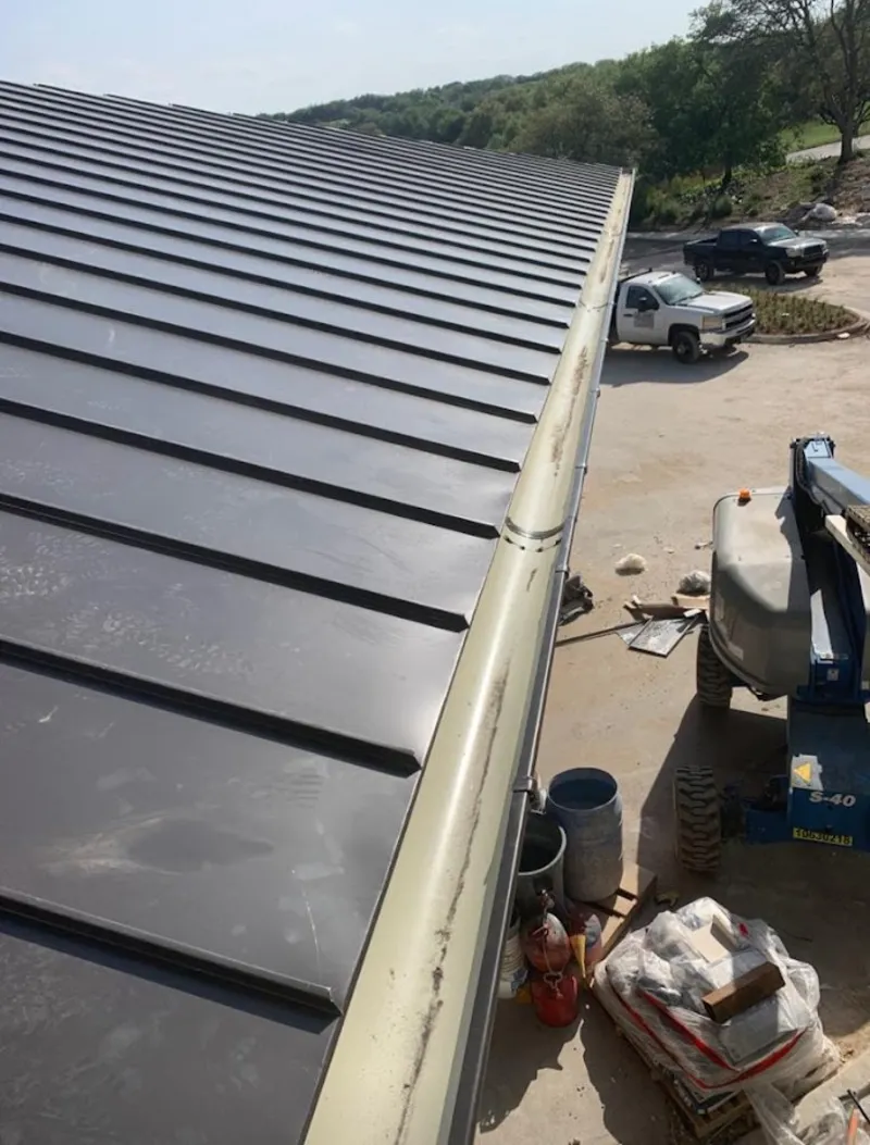 Standing seam panel and gutter detail on a metal roofing jobsite in Horace